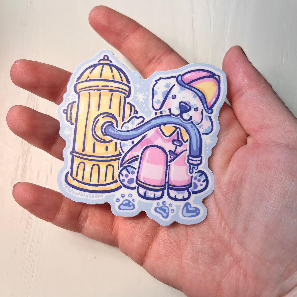 Hand holding a colorful sticker of a dog and fire hydrant on a light background