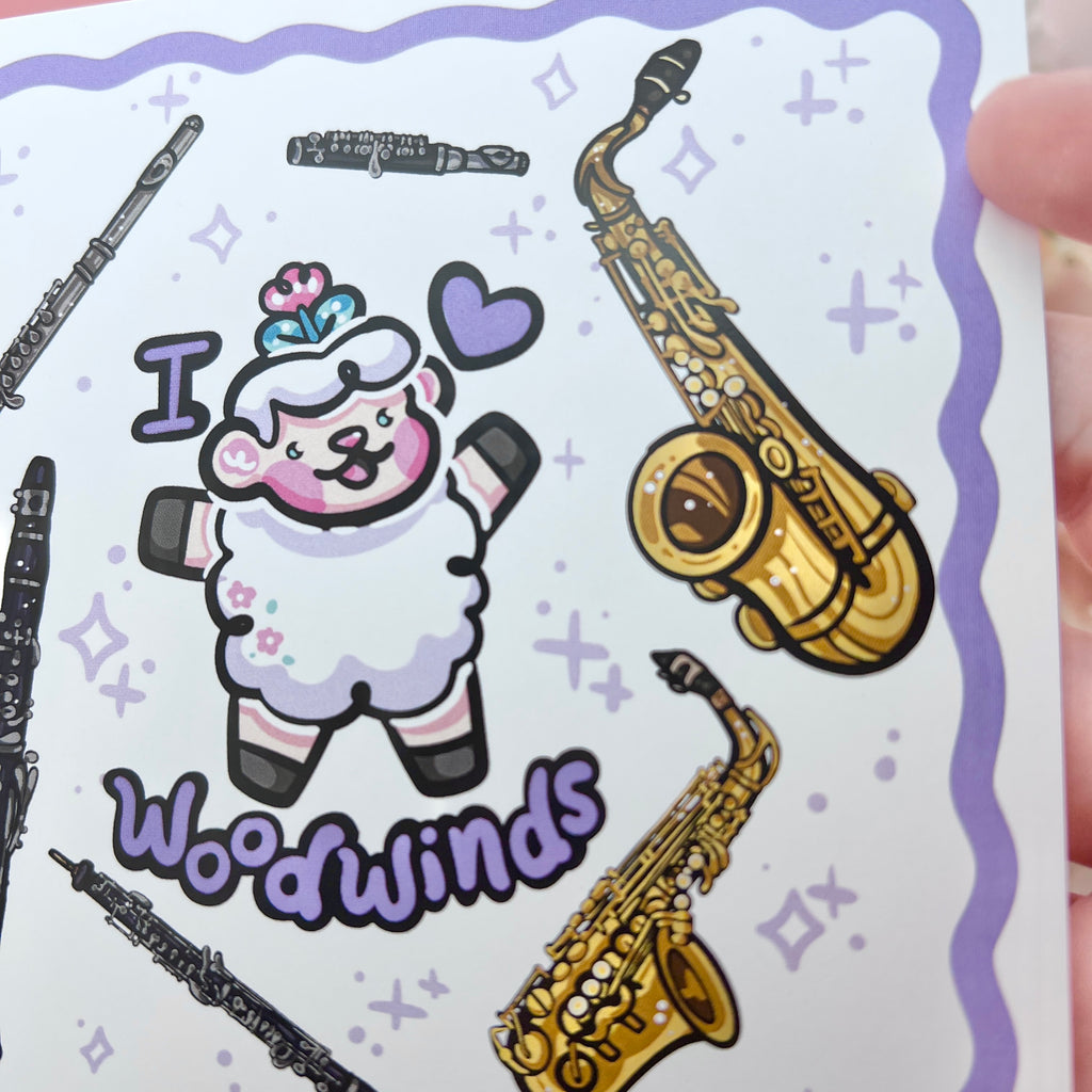 a print of a sheep with the text "I heart woodwinds" and six instruments floating around them (flute, piccolo, tenor sax, alto sax, oboe, clarinet)