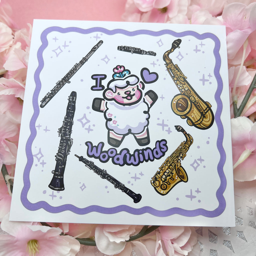 a print of a sheep with the text "I heart woodwinds" and six instruments floating around them (flute, piccolo, tenor sax, alto sax, oboe, clarinet)