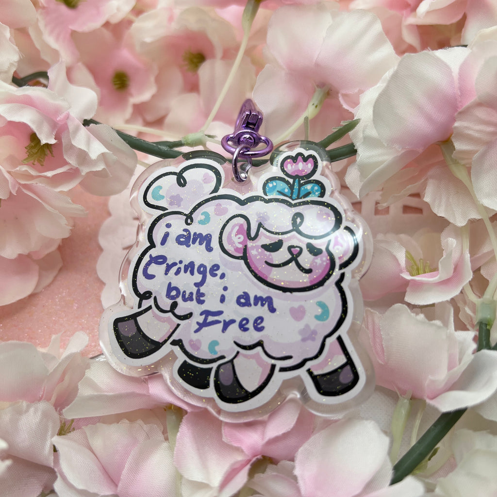 A keychain of sprout the flower sheep mid gallop, with purple text on their wool that says "i am cringe, but i am free"