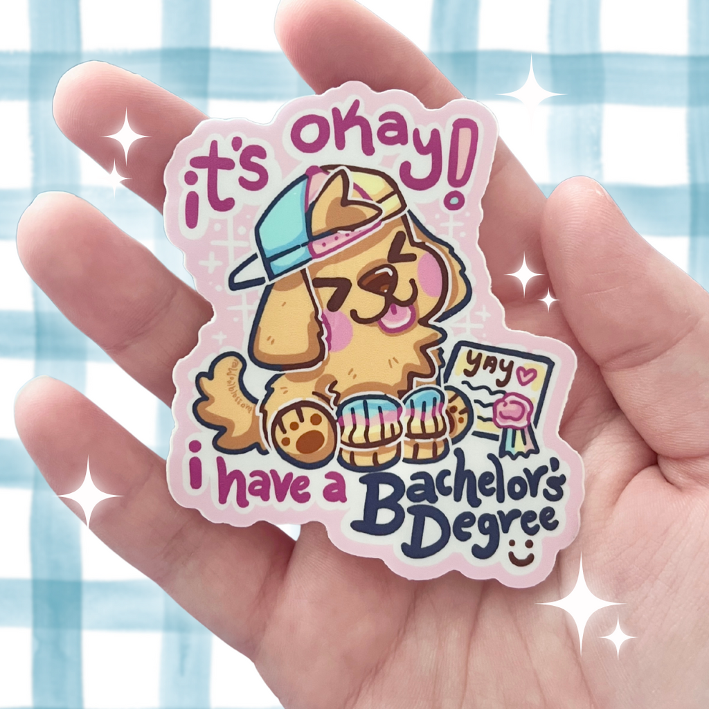 Sticker with a cartoon dog and text that says "it's okay! i have a bachelors degree" held in a hand against a checkered background