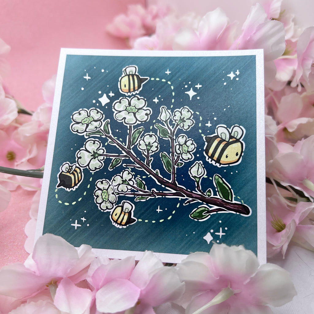 A print of a branch of dogwood flowers with 3 bees flying around