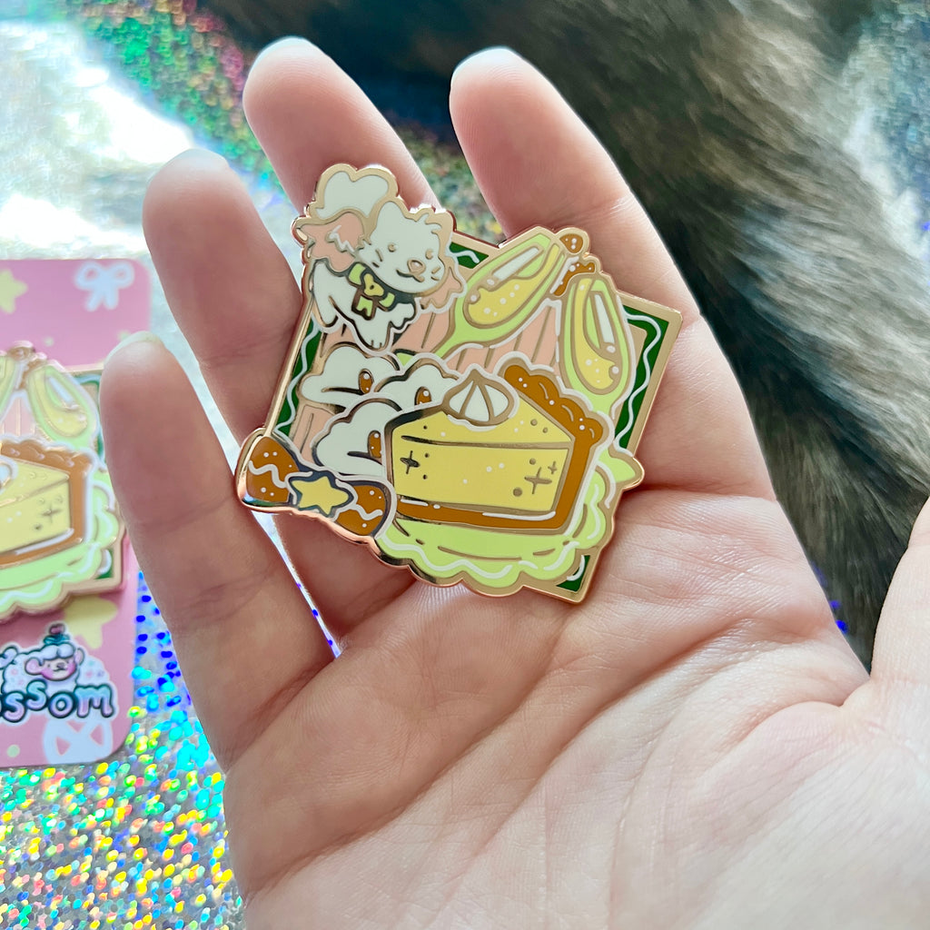 Enamel pin of a of a white angel cat flying around a celebration meal  held in a hand