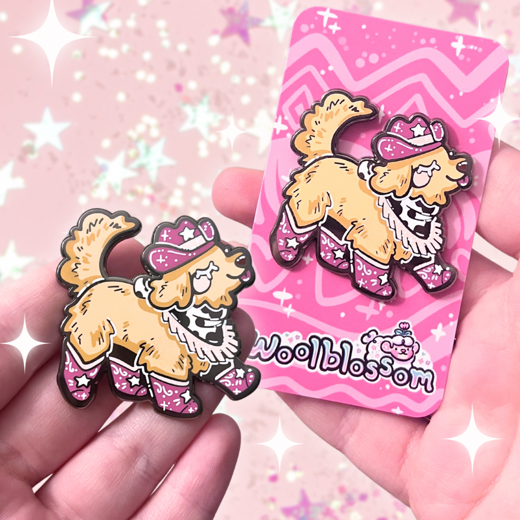 An enamel pin of a golden retriever happily stepping, dressed in a pink cowgirl hat, boots, and bandanna 