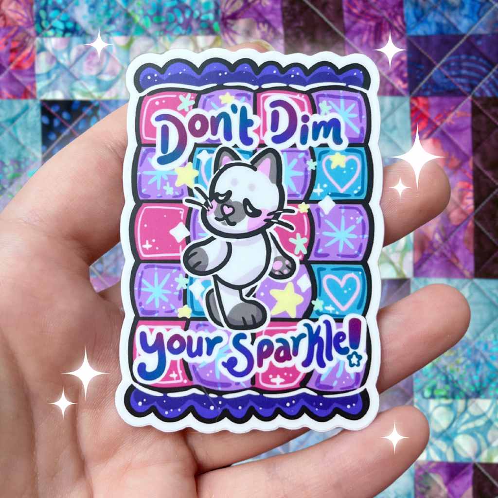 A cat walking with text that says "don't dim your sparkle!" on top of a purple quilt pattern