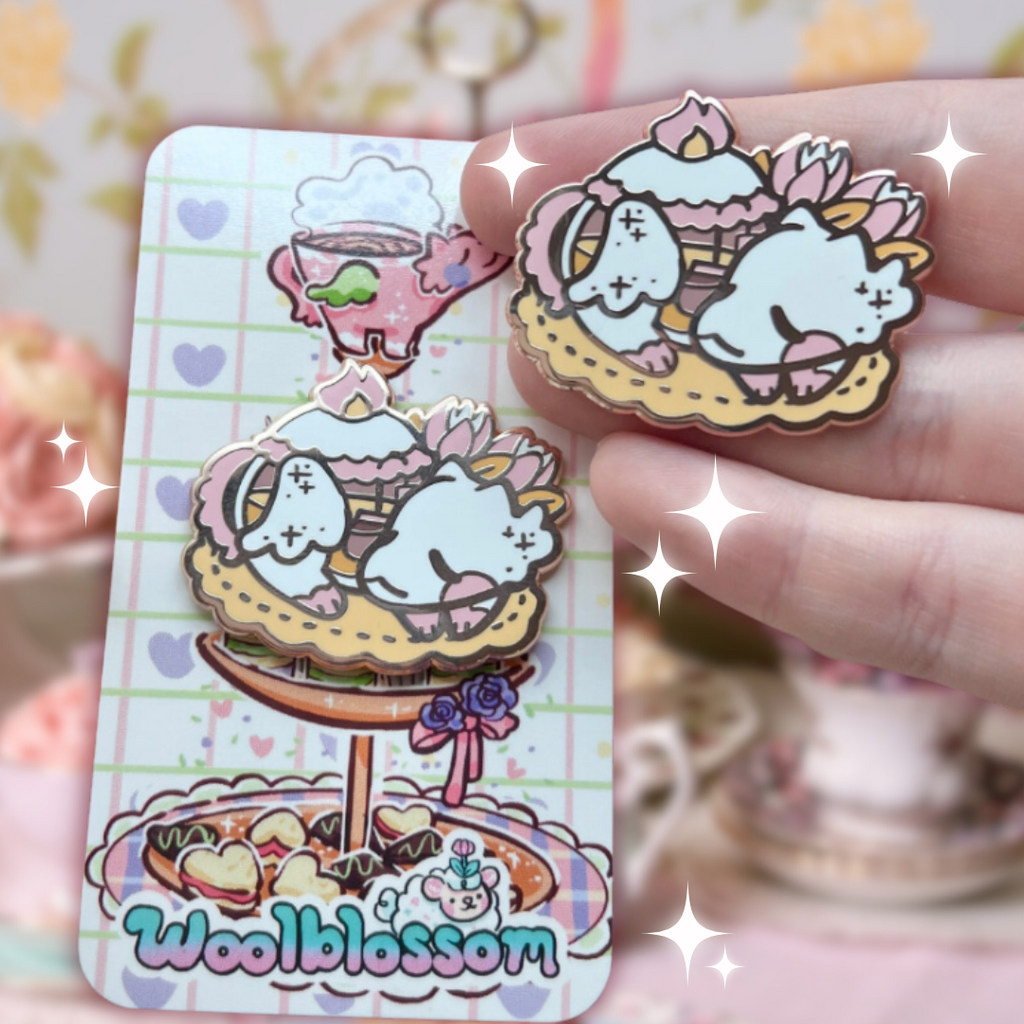 An enamel pin of a tea pot dragon curled up on a table matt, asleep