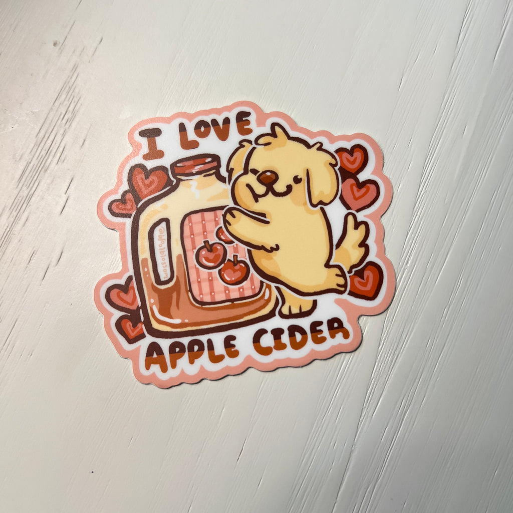Sticker with a dog holding an apple cider jar and 'I love apple cider' text on a light background