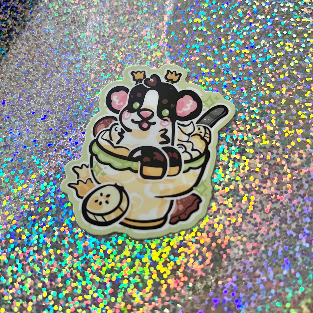 A sticker of a daffodil cow in banana pudding on a glittery background