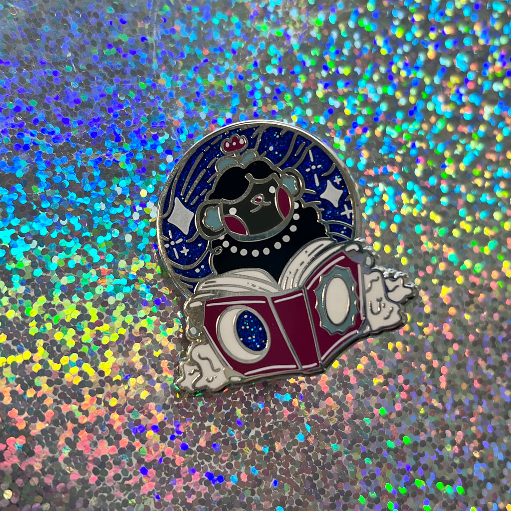 Pin of the reading sheep on a glittery background
