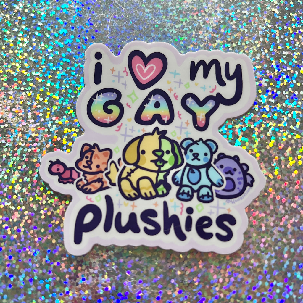 Sticker with 'i ❤️ my GAY plushies' text and rainbow-colored plushies on a glittery background