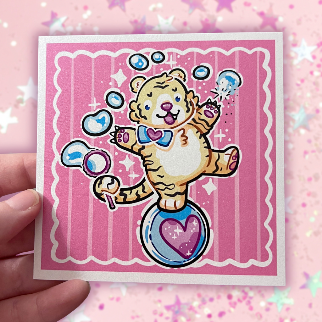 A print of a cute tiger balancing on a ball, bubble wand in tail, reaching up and poking the bubbles with his claws. Pink aesthetic overall.