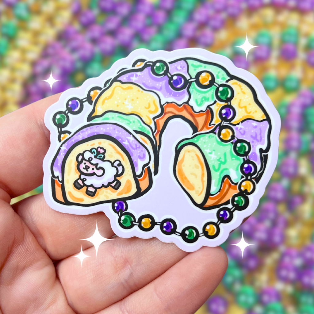 A sticker of king's cake sliced open with a baby sprout inside instead of a plastic baby