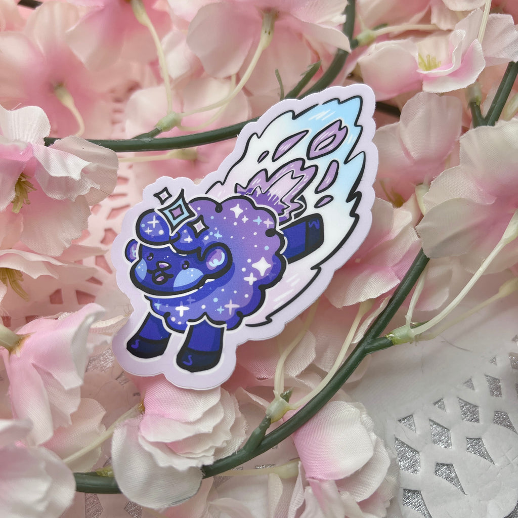 a sticker of a dark purple/blue sheep made to seem like a shooting star, with glittery details and trail behind them