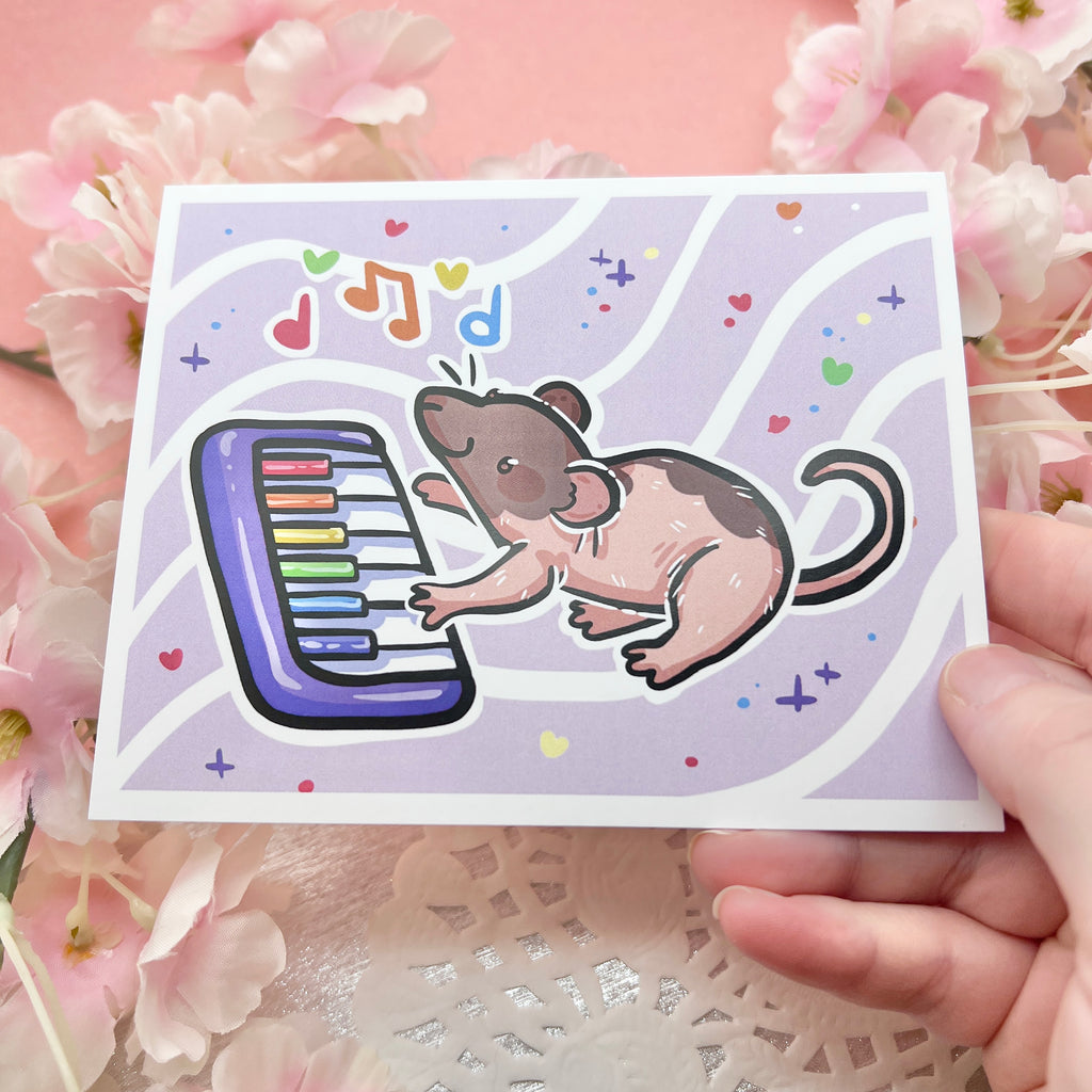 A print of a brown/pink mostly hairless rat playing a rainbow piano