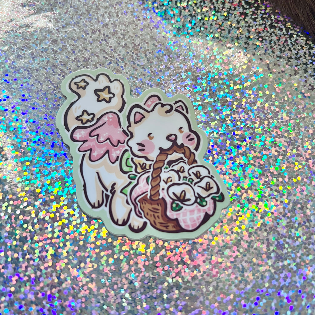Sticker of a cat with a basket of flowers on a glittery background