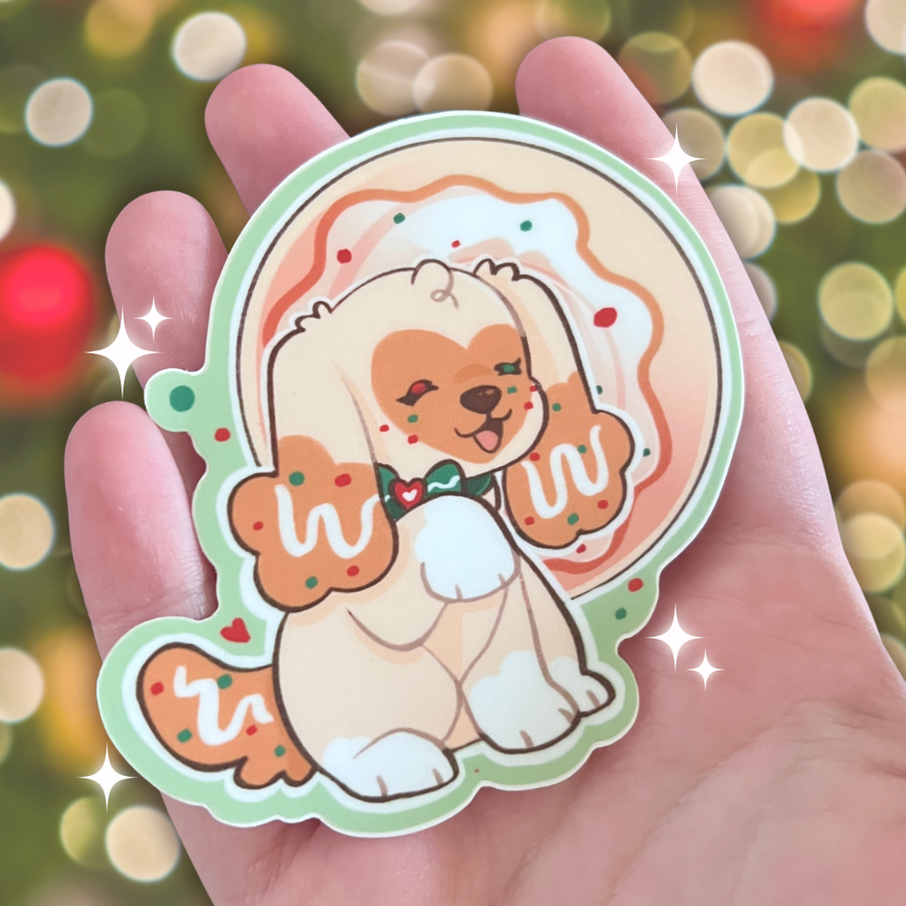 A sticker of a golden puppy in front of a sugar cookie