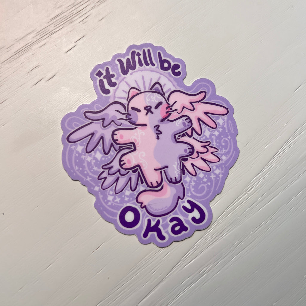 Sticker with a cartoon angel cat and 'it will be okay' text on white