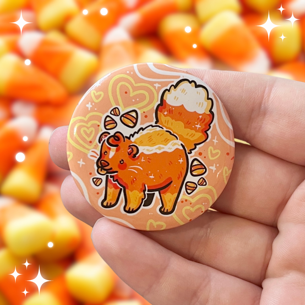 A button of a candy corn colored skunk