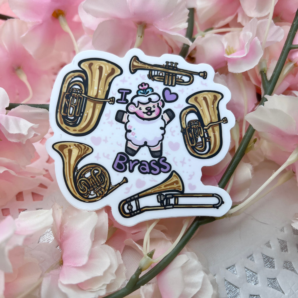 a sticker of a sheep with the text "I heart brass" and five instruments floating around them (tuba, trumpet, euphonium, trombone, and french horn)