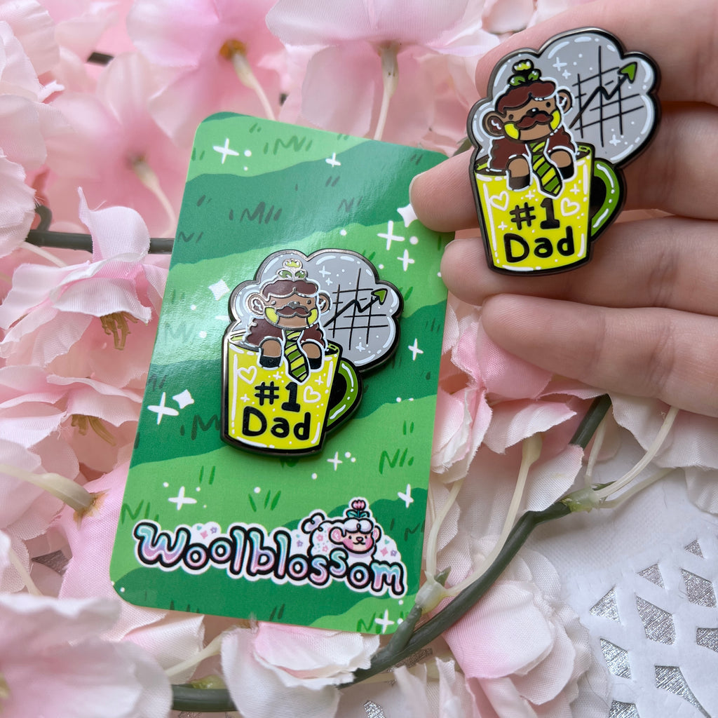 an enamel pin of a brown sheep with a mustache and tie in a yellow coffee cup that says "#1 dad" and steam rising up that has an upward trajectory chart in it