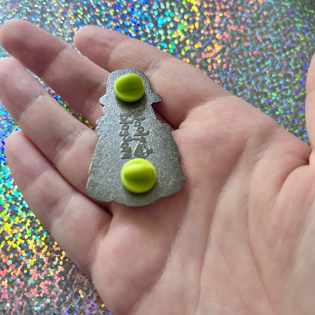 Hand holding the back of the pin to show backstamp