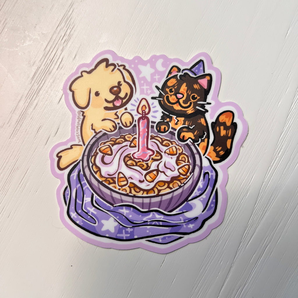 Sticker of a dog and cat by a birthday cereal with a candle on a white background