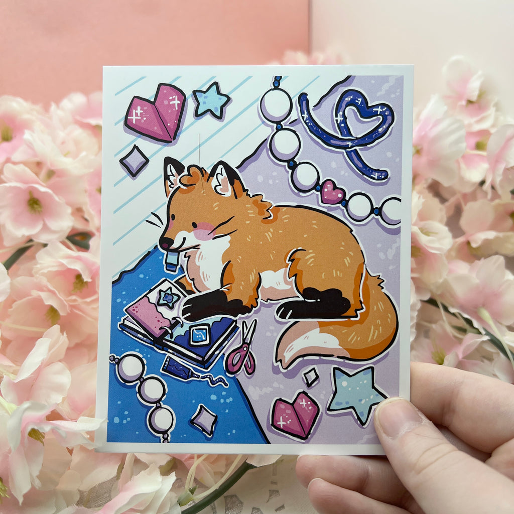 A print of a cute red fox scrapbooking away