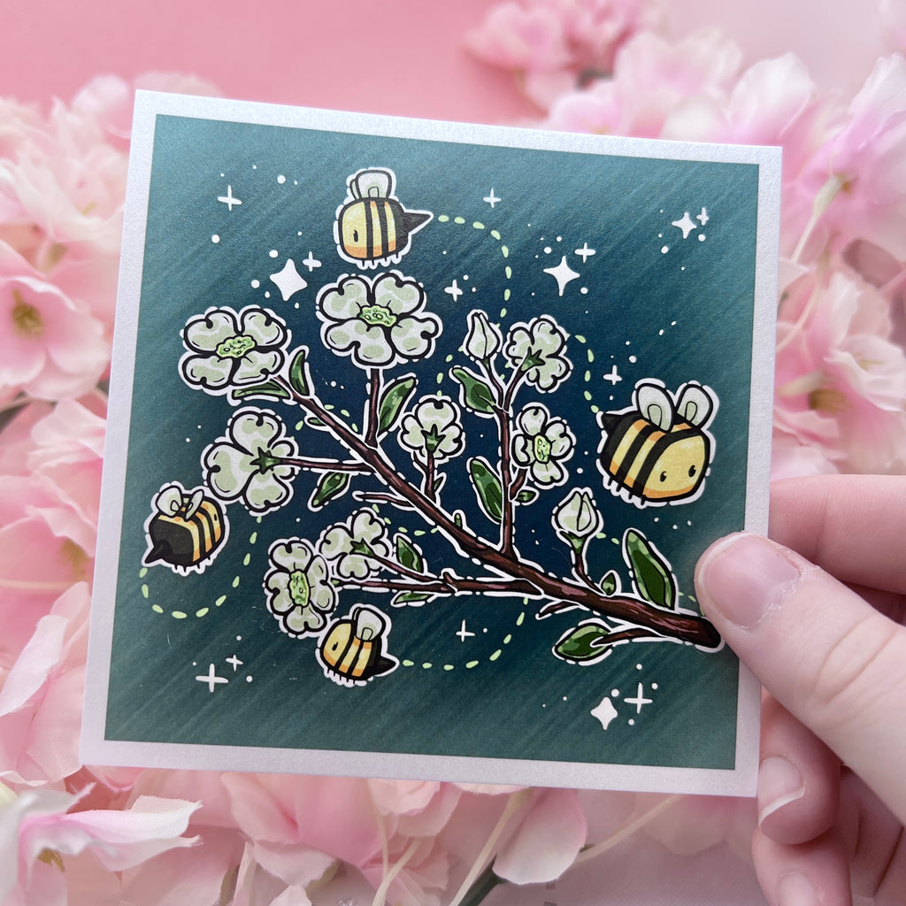 A print of a branch of dogwood flowers with 3 bees flying around