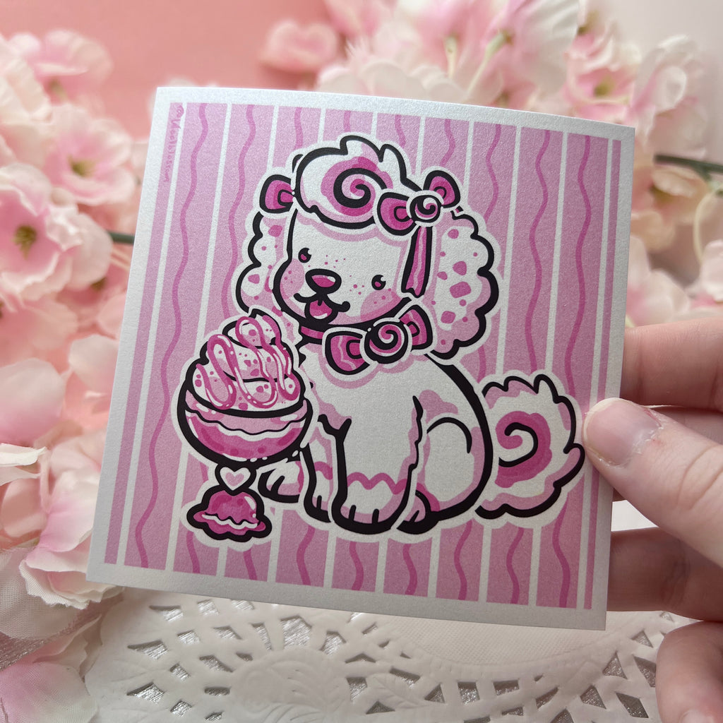 A print of a white puppy with pink accents and bows eating ice cream