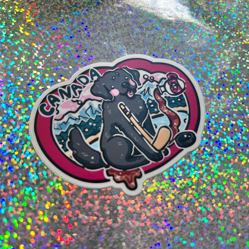 Sticker of a black dog, hockey stick, and 'Canada' text on a glittery background