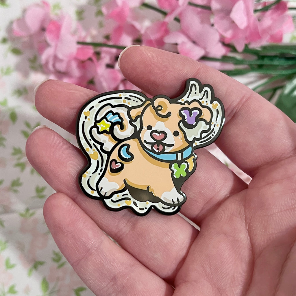 An enamel pin of a marshmallow cereal puppy in front of a wave of milk