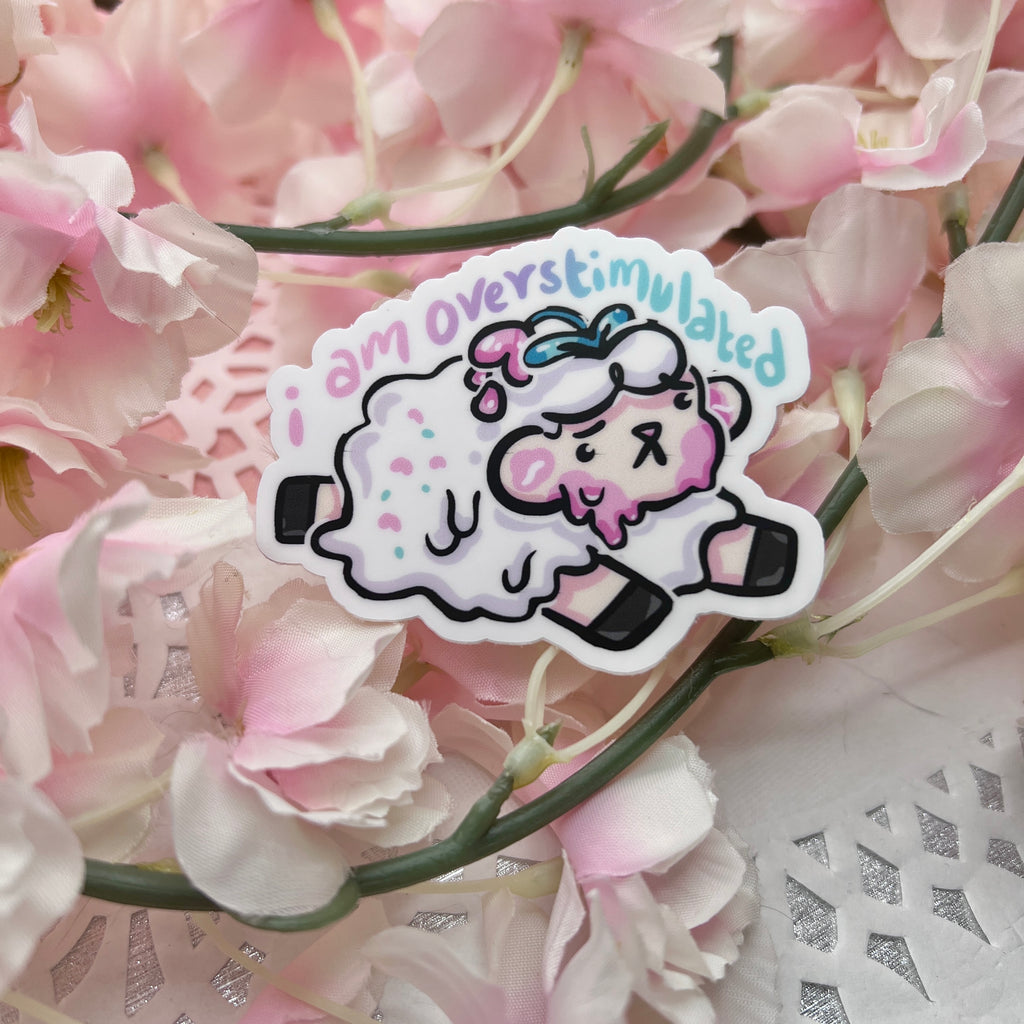 a sticker of a sheep that is slightly melting with the text "i am overstimulated" on top