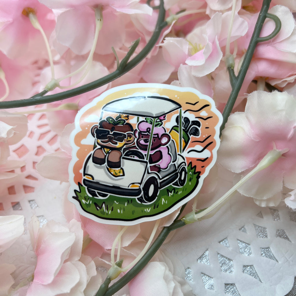 a sticker of a brown sheep with a mustache and a tie in a golf cart with a pink mustache sheep driving, a sunset behind them