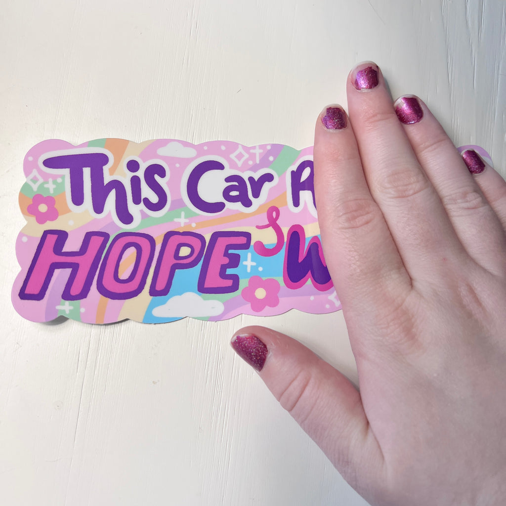  a colorful bumper sticker with text 'This Car Runs On HOPE & WHIMSY' with hand