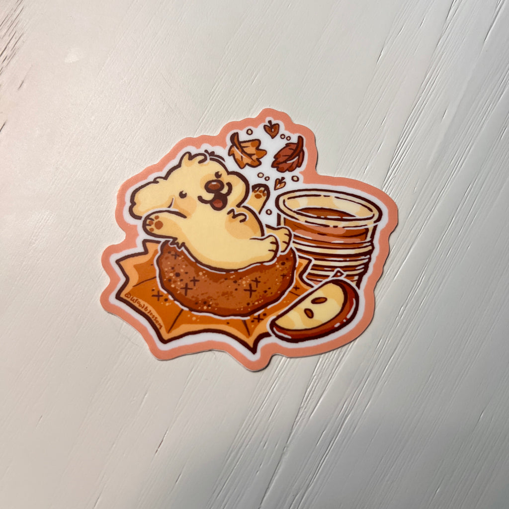 Sticker of a golden retriever on an apple doughnut on white