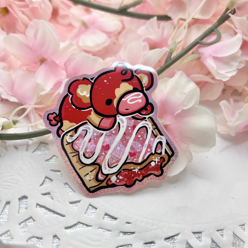 A sticker of a red and tan cow on top of a glitter pink strawberry pastry