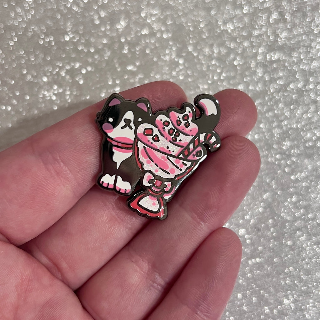 Enamel pin of a black tuxedo peeking out from a peppermint sundae