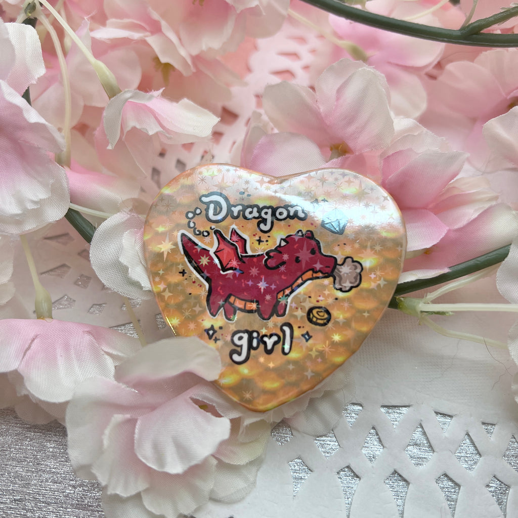 a heart button that says dragon girl with a red dragon in front of yellow scales