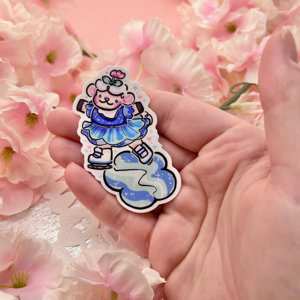 A sticker of Sprout the sheep on their hind legs skating on a flower patch of ice. They are in a blue glittery dress.