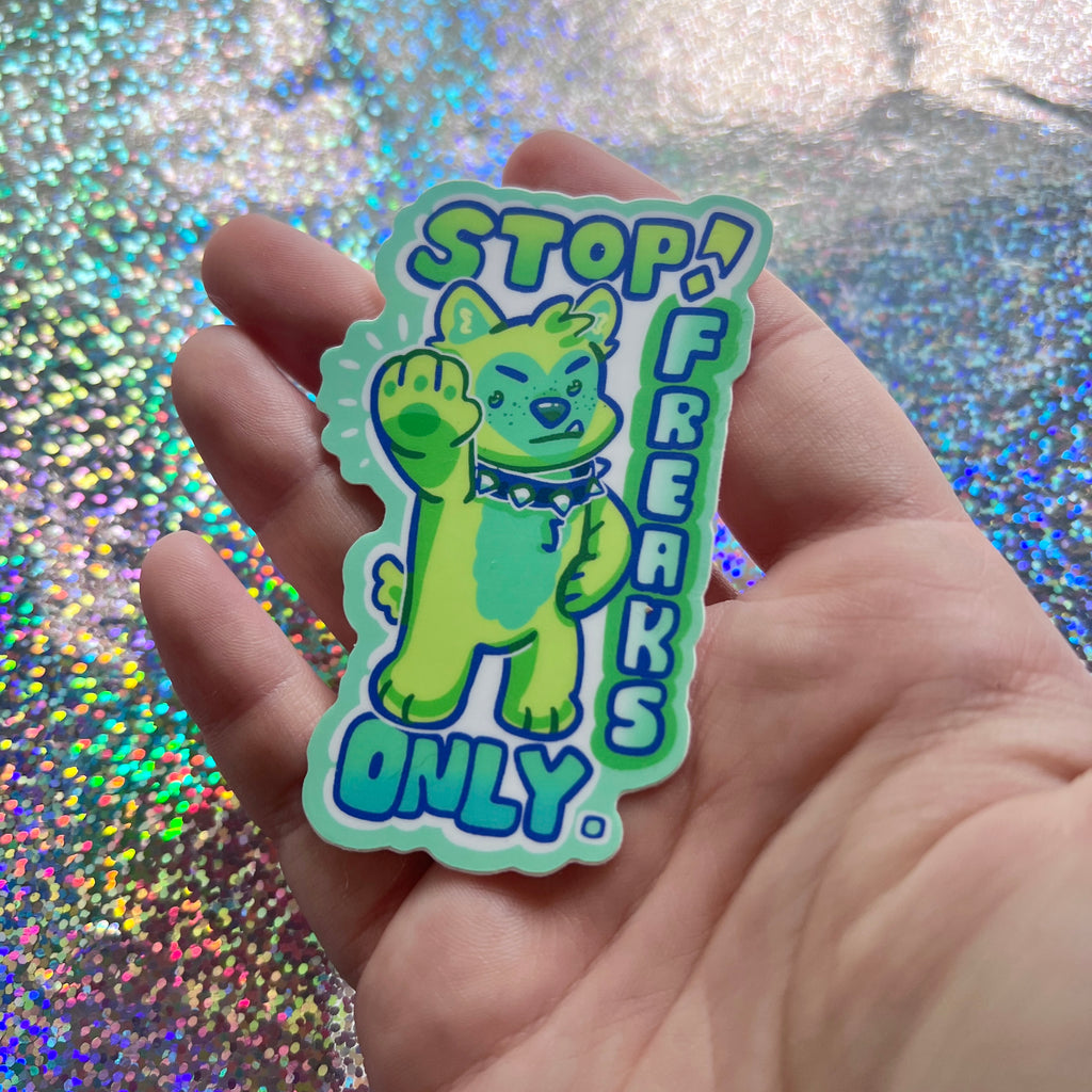 A sticker that has a green puppy holding their hand out with text that says "stop! freaks only."