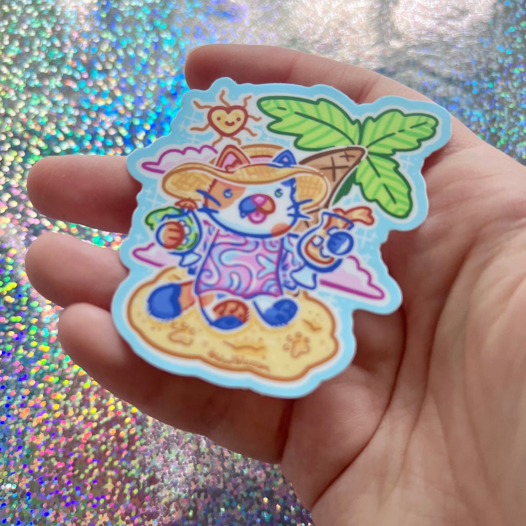 A sticker of a calico cat with drinks in hand, on a beach, in a sun hat and dress