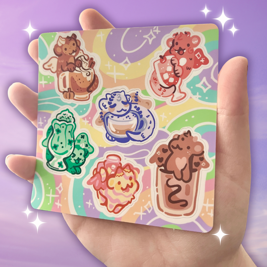 Set of colorful drink dragons on a sticker sheet held in a hand against a purple background