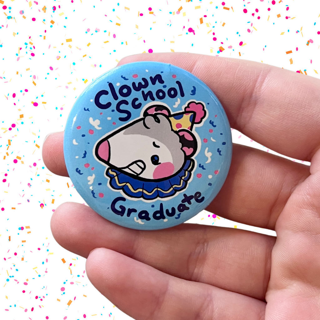 A button of a clown opossum with the text "clown school graduate"