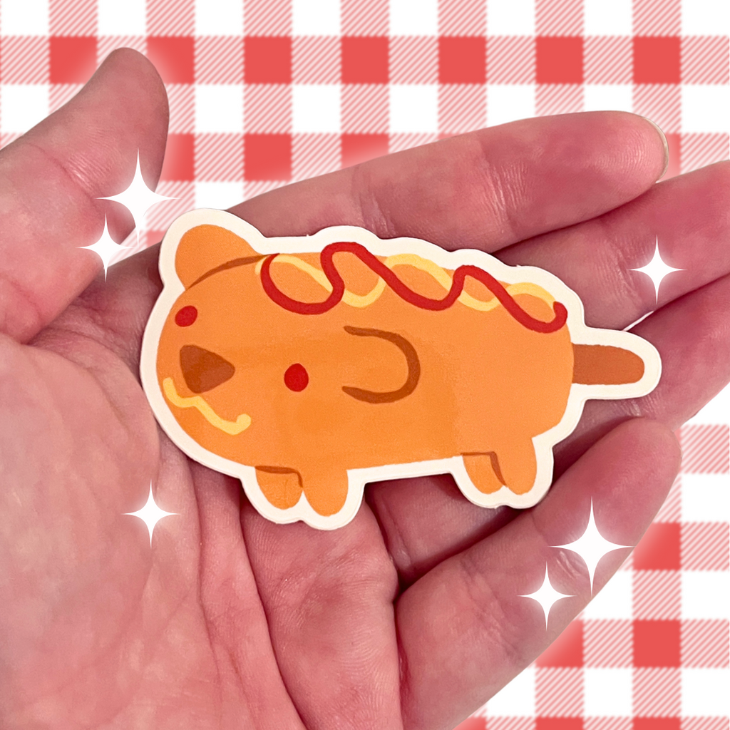 A sticker of a corn dog that has the shape and features of a corn dog