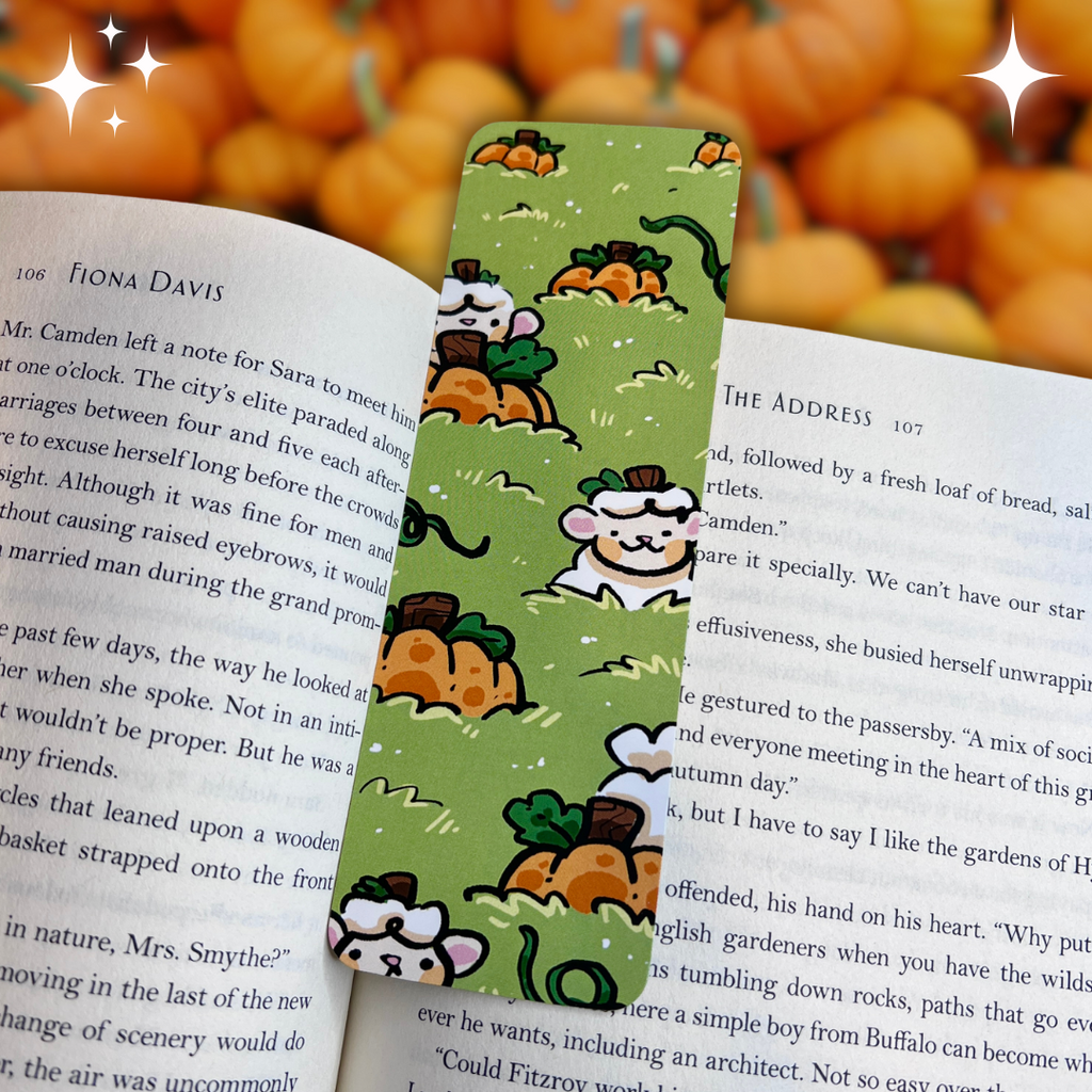 A bookmark of a pumpkin patch with a white sheep sticking their head up across the design