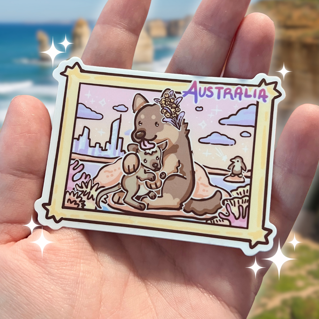 a sticker of an Australian shepherd licking a kangaroo on the Australian beach