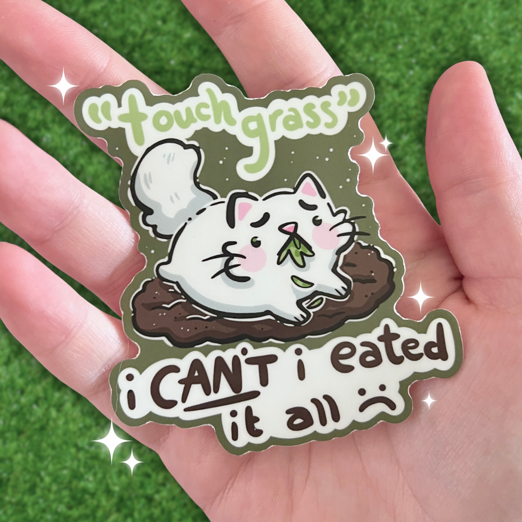 A sticker of a white cat on dirt with grass in its mouth and text that says "touch grass- i cant i eated it all :("