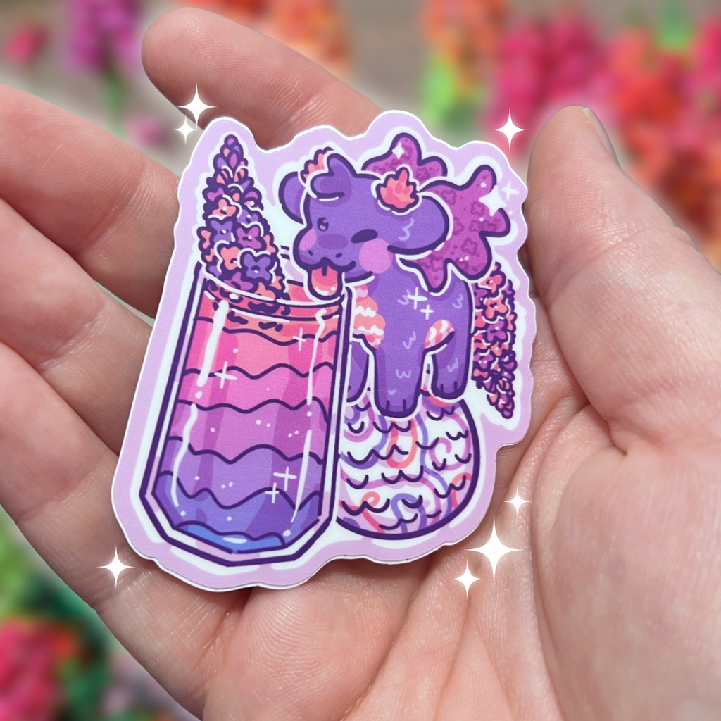 Hand holding a colorful sticker with a purple dragon and flower design drinking out of a cup
