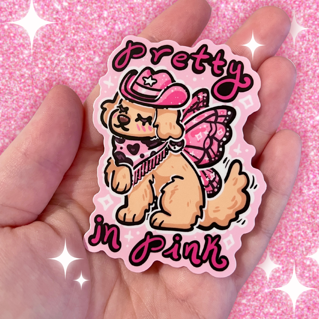 a sticker of a golden retreiver with a pink cowgirl hat, boots, and dark pink fairy wings and text that says "pretty in pink"