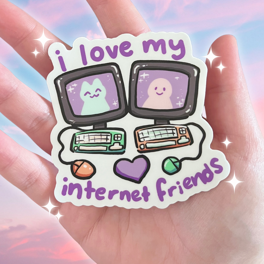 Sticker with cartoon pcs and text 'i love my internet friends' held in a hand against a soft focus background.